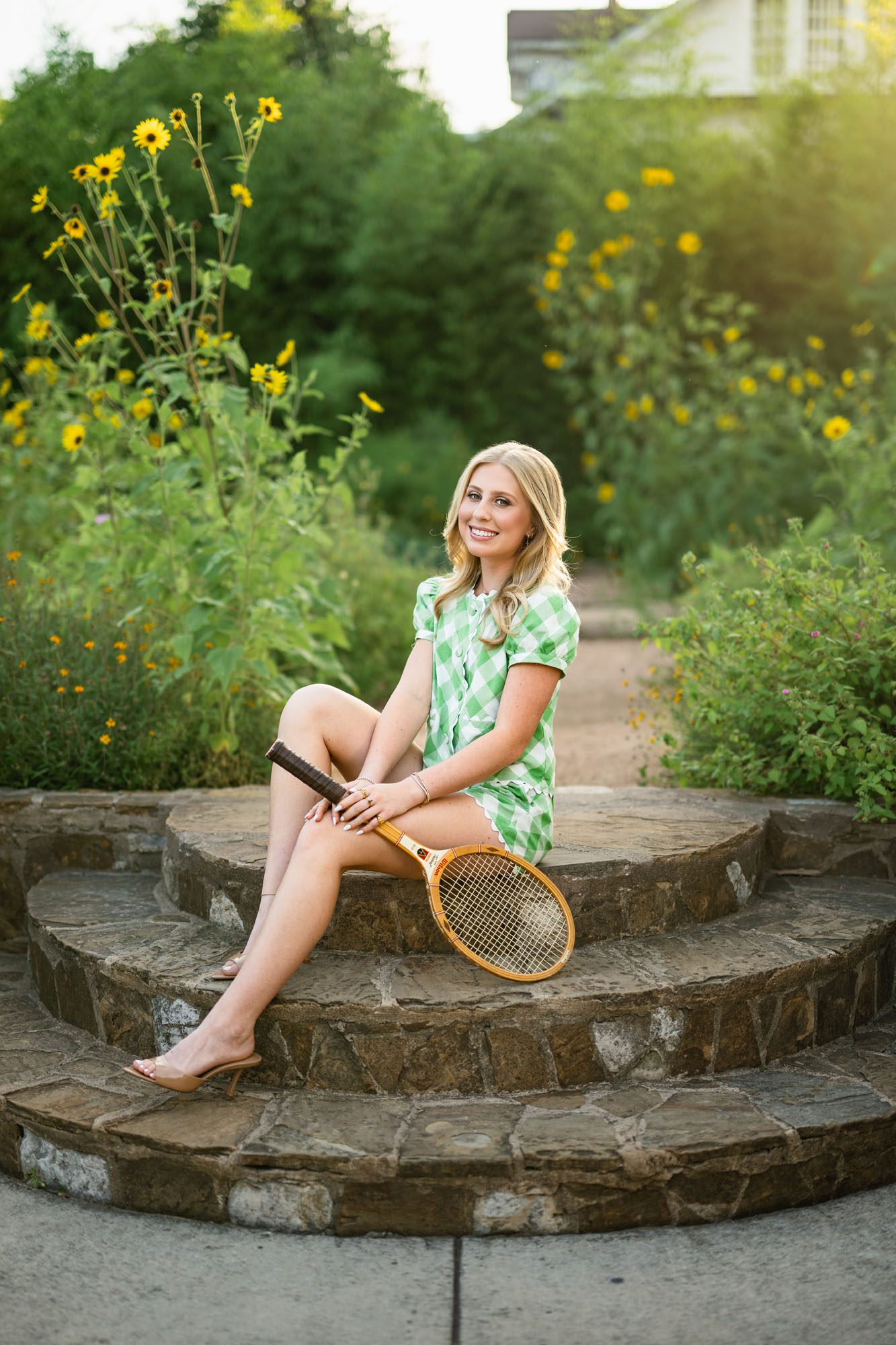 High school senior girl sitting in garden with tennis racket, San Antonio senior photographer